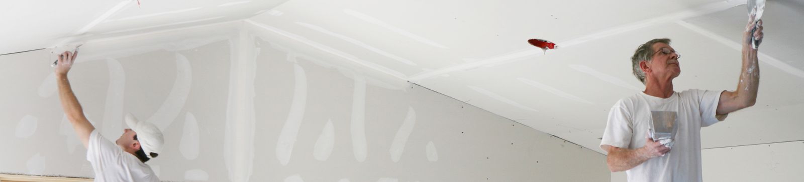 Two men plastering the ceiling